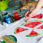 Drawing on clothes. Girl draws on a white T-shirt